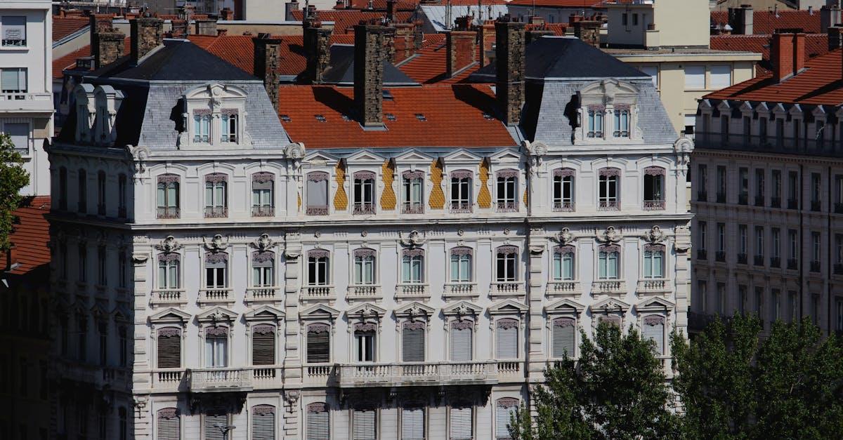 Ornate white facade of historic building with red roof tiles in Europe.